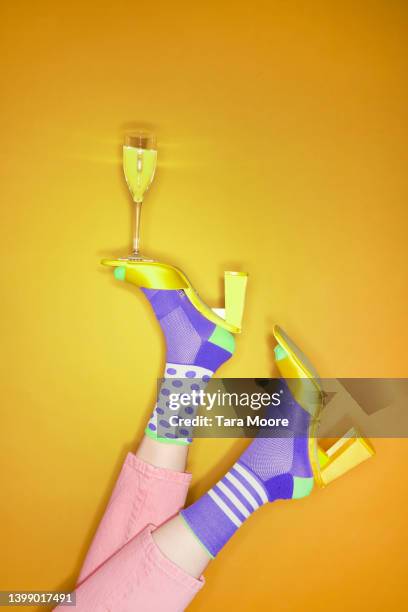 vibrant foot balancing glass of champagne - colorful shoes ストックフォトと画像