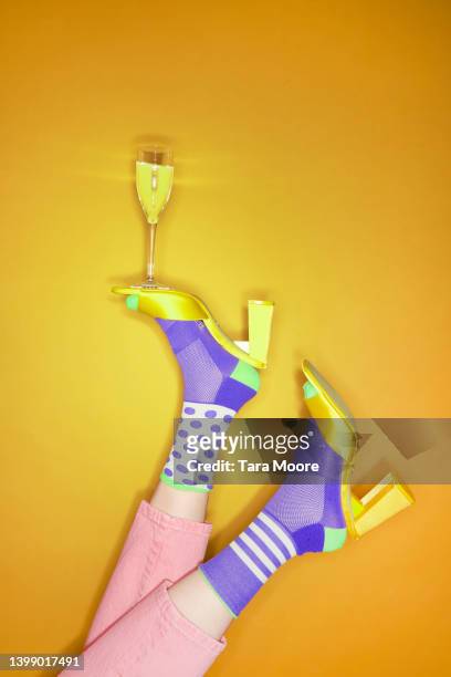 vibrant foot balancing glass of champagne - multi coloured shoe imagens e fotografias de stock