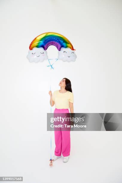 woman holding rainbow balloon - helium stock-fotos und bilder