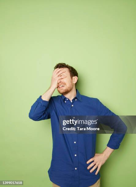 man looking upset covering face - hand on hip pain stock pictures, royalty-free photos & images