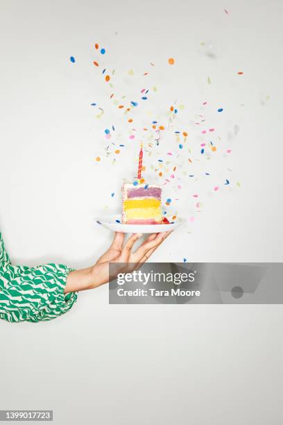 hand holding birthday cake with confetti - woman holding cake stock-fotos und bilder