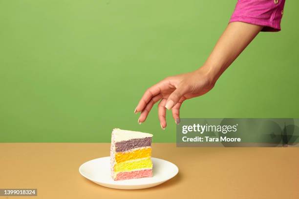 hand reaching for cake - cake slices stock-fotos und bilder