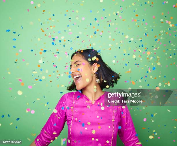 woman celebrating with confetti - excitement photos et images de collection