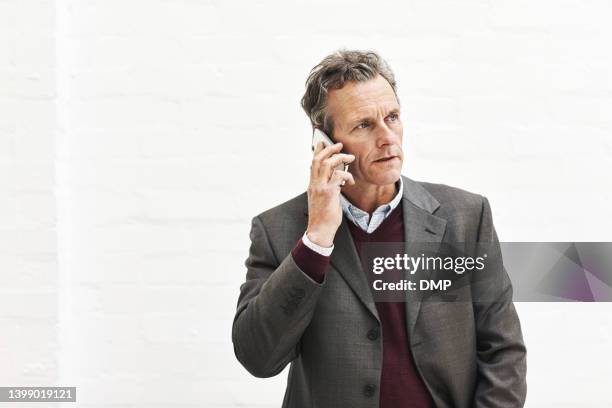 a businessman using a phone to make a call, isolated on a white background. a mature male executive talking on a smartphone for business in an office or studio - business man isolated bildbanksfoton och bilder