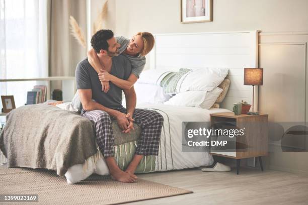 ein paar, das sich zu hause im bett umarmt. ein glücklicher, reifer mann und eine verliebte frau, die sich morgens im schlafzimmer entspannen und sich umarmen - paar kuscheln bett stock-fotos und bilder