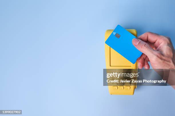 yellow credit card pos terminal on blue background - nfc icon stock pictures, royalty-free photos & images
