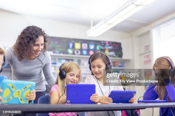 elementary students using technology at school - pedagoga imagens e fotografias de stock