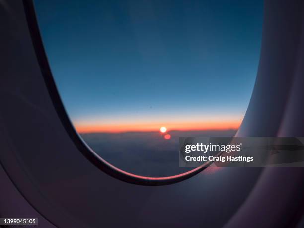 looking through airplane window during take off at dusk to reveal an amazing sunset. concept image to promote marketing around travel, tourism, flights, aviation, global business, adventure, exploration and freedom - airplane runway stock-fotos und bilder