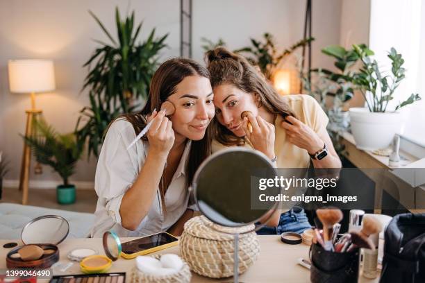 two happy girls applying make up at home - applying make up stock pictures, royalty-free photos & images