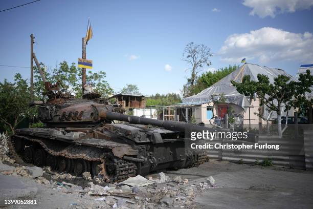Children's cuddly toy sits on top of a destroyed Russian main battle tank, next to war damaged homes, on May 24, 2022 in Hostomel, Ukraine. As Russia...