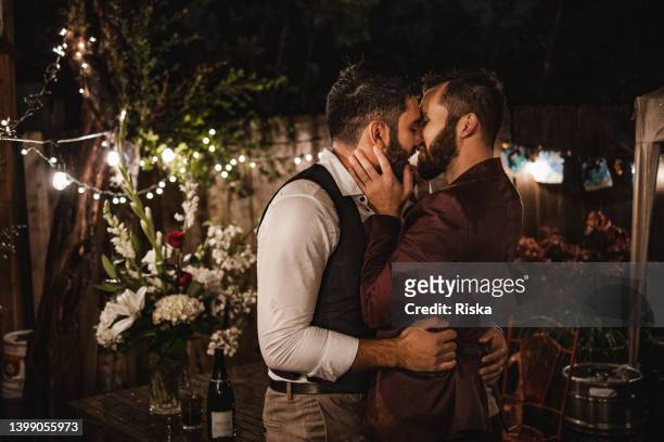 gerade verheiratetes schwules paar küsst sich bei der zeremonie - indian men gay stock-fotos und bilder