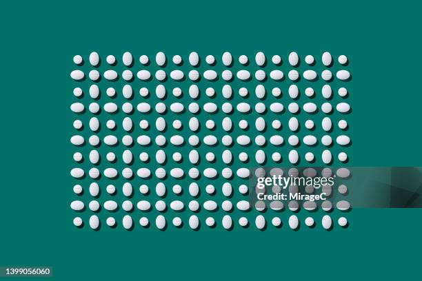 a variety of white pills neatly arranged in a rectangle - tabletten schlucken stock-fotos und bilder