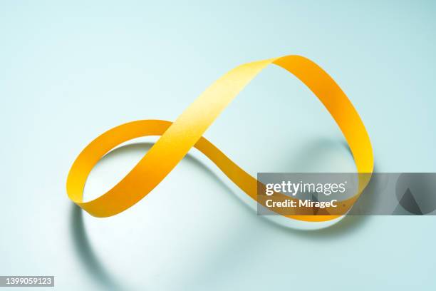 mobius strip made of yellow paper strip - life cycle stock pictures, royalty-free photos & images