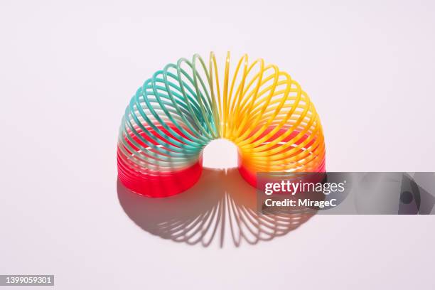 colorful coil toy arch bending on pink background - mola objeto manufaturado - fotografias e filmes do acervo