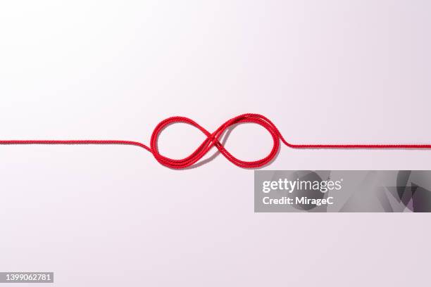 red rope connected infinity symbol - rode draad stockfoto's en -beelden