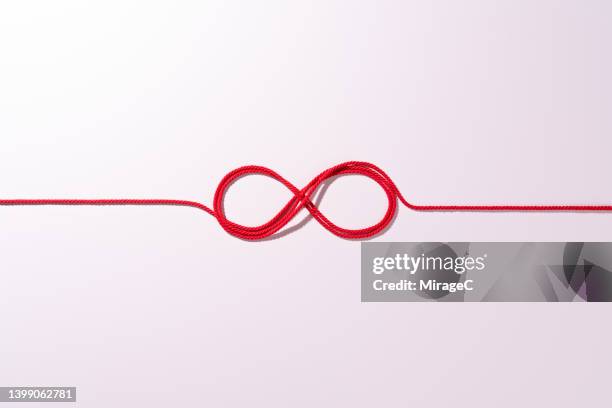 red rope connected infinity symbol - red tie stock pictures, royalty-free photos & images