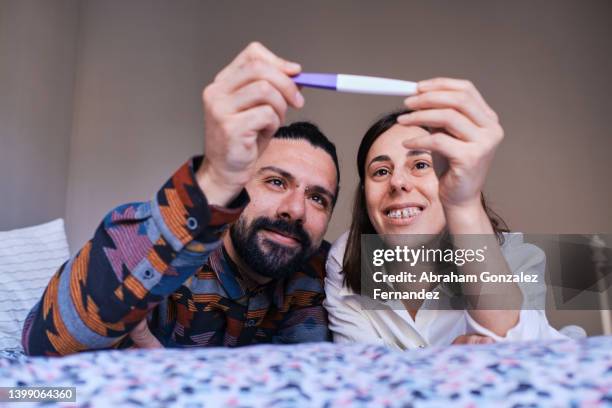 couple look at the pregnancy test happily. - woman smiling facing down stock pictures, royalty-free photos & images