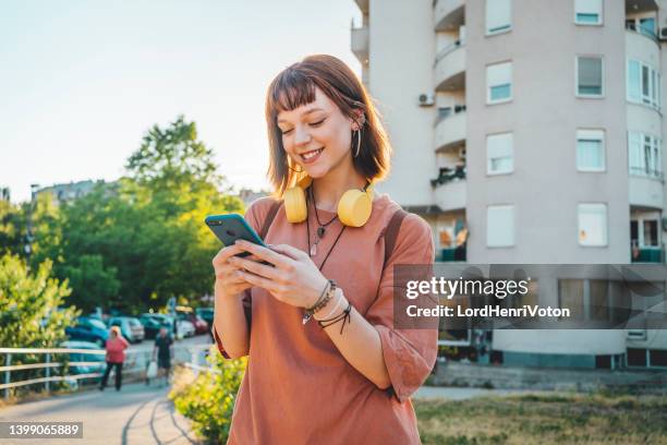 femme à l’aide de smartphone en plein air - équipement de télécommunication photos et images de collection