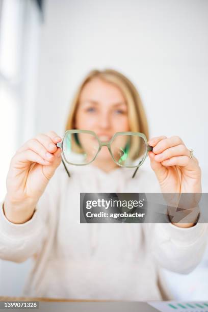 woman hand holding eyeglasses - eyesight stock pictures, royalty-free photos & images