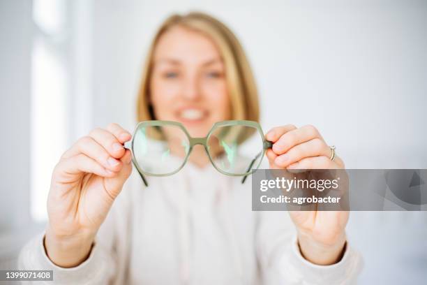 woman hand holding eyeglasses - eyesight stockfoto's en -beelden