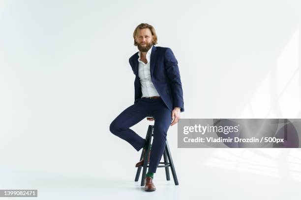 a handsome brutal bearded and long-haired man,a stylish businessman - blue pants stock pictures, royalty-free photos & images