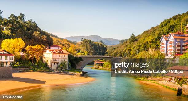 scenic view of river by buildings against sky,lequeitio,vizcaya,spain - biskaje stockfoto's en -beelden