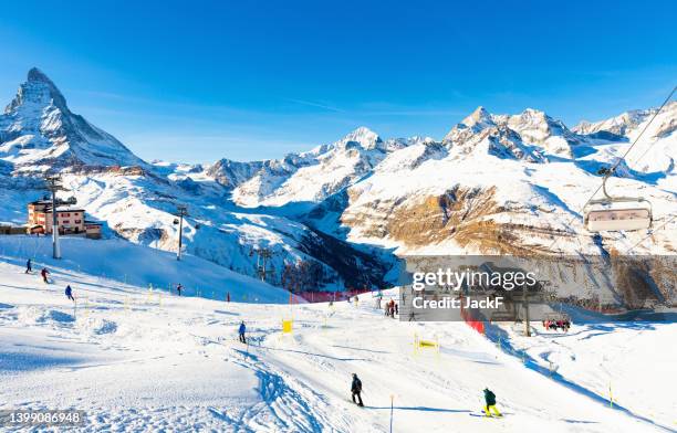 View of mountain Matterhorn in Alps on winter day with ski lifts at its foot, Switzerland
