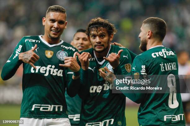 Gustavo Scarpa of Palmeiras celebrates with teammates Rafael Navarro and Zé Rafael after scoring the second goal of his team during a match between...