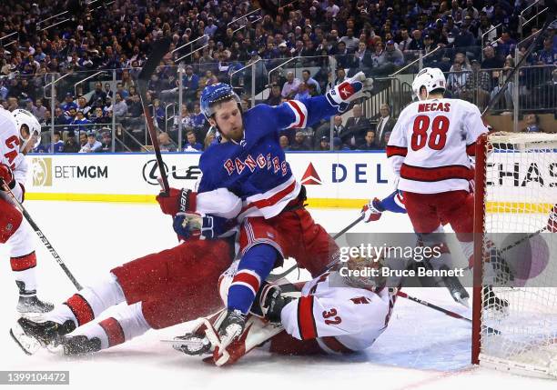 Alexis Lafreniere of the New York Rangers crashes into Antti Raanta of the Carolina Hurricanes during the third period in Game Four of the Second...