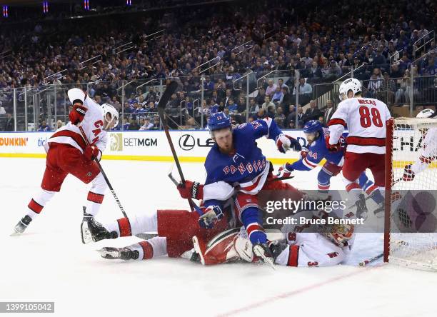 Alexis Lafreniere of the New York Rangers crashes into Antti Raanta of the Carolina Hurricanes during the third period in Game Four of the Second...