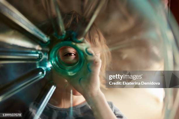 cute smiling young small boy with plastic bottle looking through funny eye - transparent photos et images de collection