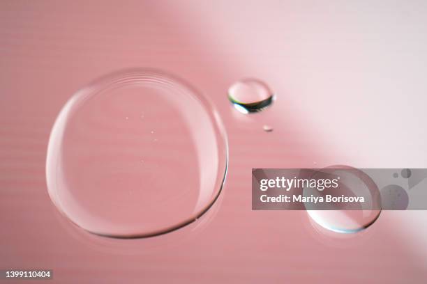 a drop of gel, micellar water or cosmetic oil on a pink background. - oily skin stock pictures, royalty-free photos & images