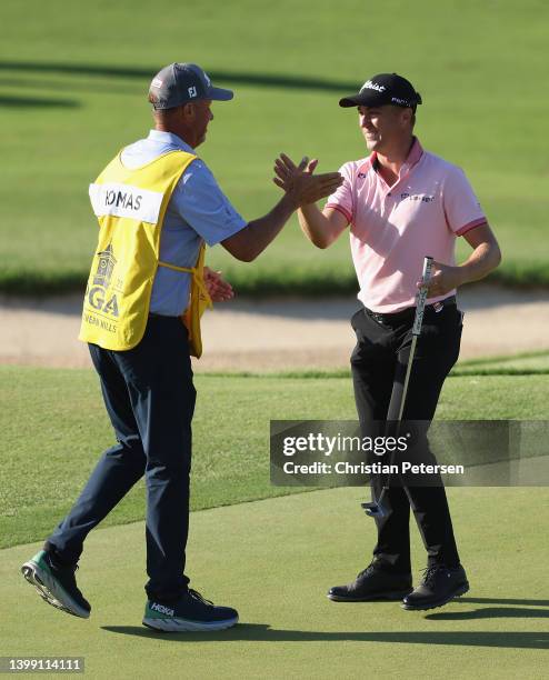 Justin Thomas of the United States reacts to his winning putt on the 18th hole with caddie Jim "Bones" Mackay, the third playoff hole during the...