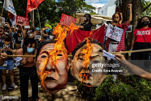 Anti-Marcos activists burn an effigy of Ferdinand "Bongbong" Marcos Jr. And Sara Duterte as they take part in a protest against election results at...