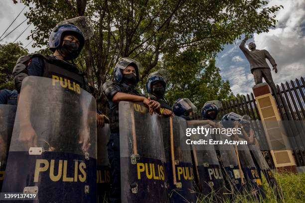 Riot police officers stand guard as anti-Marcos activists take part in a protest against election results at the Commission on Human Rights office on...