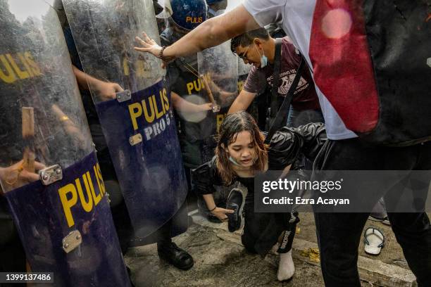 Anti-Marcos activists clash with riot police officers during a protest against election results at the Commission on Human Rights office on May 25,...