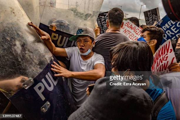 Anti-Marcos activists clash with riot police officers during a protest against election results at the Commission on Human Rights office on May 25,...