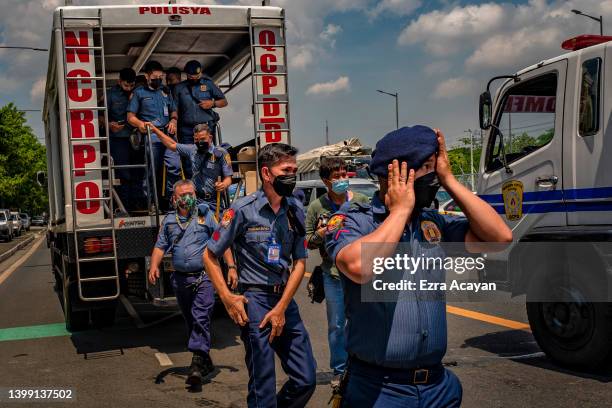 Riot police officers take position as anti-Marcos activists take part in a protest against election results at the Commission on Human Rights office...