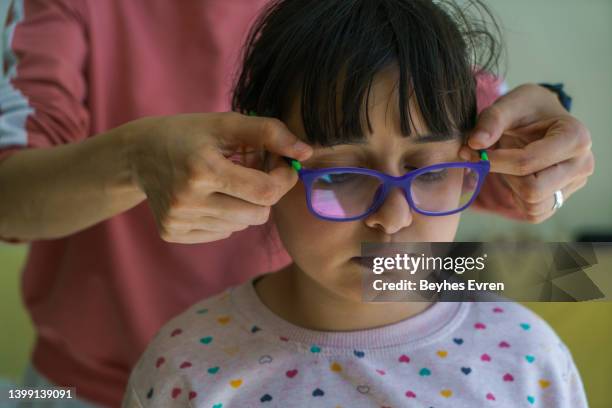 doctor giving the child new glasses - optical equipment stock pictures, royalty-free photos & images