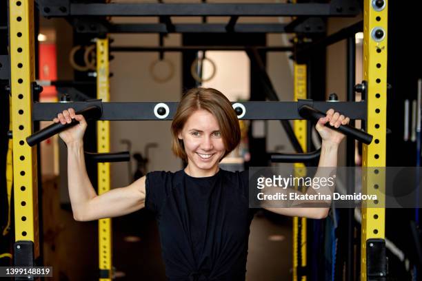 portrait of a smiling woman pulling up in gym - black female bodybuilder stock pictures, royalty-free photos & images