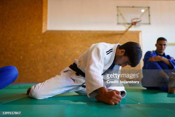 martial artists stretching before training - zwarte band stockfoto's en -beelden