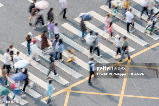 people walking on zebra crossing aerial view - commuters overhead view stock pictures, royalty-free photos & images