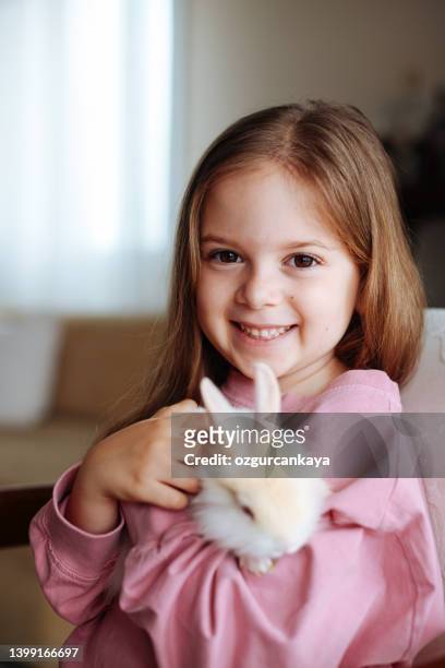 笑顔の小さな女の子と白いウサギ - white rabbit ストックフォトと画像