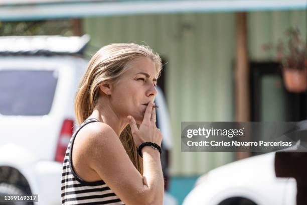 blonde woman smoking in the street - beautiful women smoking cigarettes stock pictures, royalty-free photos & images