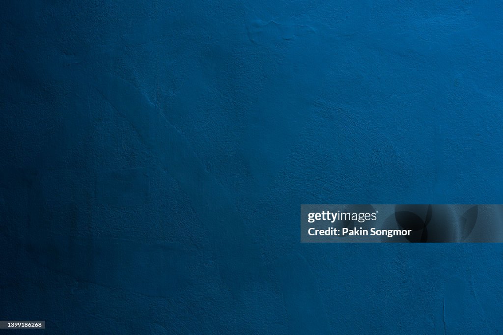 Dark blue color with an old grunge wall concrete texture as a background.
