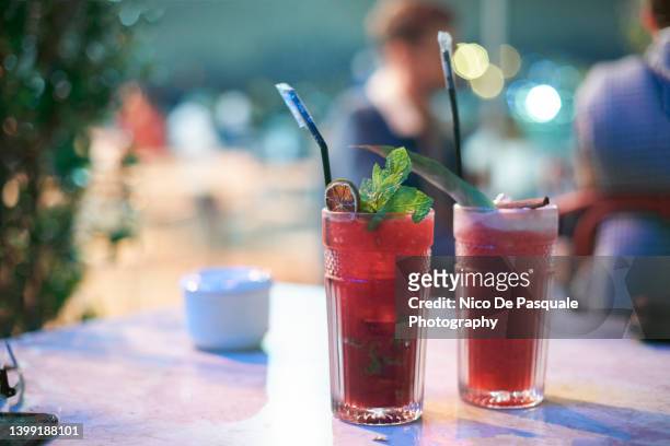 raspberry mojito and cherry caipirinha cocktails - table aperitif stock pictures, royalty-free photos & images
