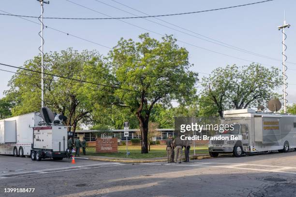 Law enforcement officers gather outside of Robb Elementary School following the mass shooting at Robb Elementary School on May 25, 2022 in Uvalde,...