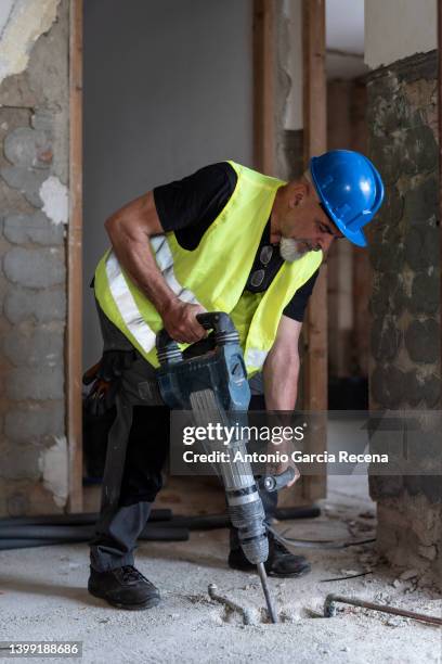 construction worker with pneumatic hammer intended to drill the cement and concrete floors - jackhammer stock pictures, royalty-free photos & images