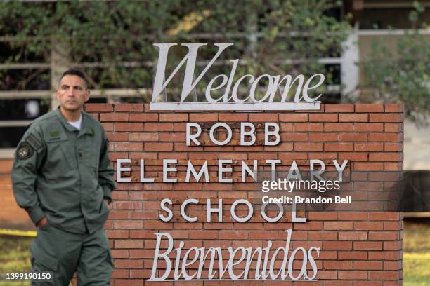 Law enforcement officer walks away from the Robb Elementary School sign on May 25, 2022 in Uvalde, Texas. According to reports, during the mass...