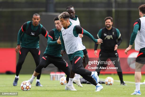 Roberto Firmino and Curtis Jones of Liverpool battle for the ball during a training session at AXA Training Centre on May 25, 2022 in Kirkby, England.